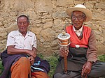 Zwei Pilger mit Gebetsmuehle in Litang